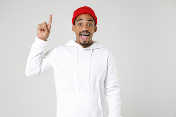 Excited amazed young african american man 20s years old wearing basic casual streetwear hoodie holding index finger up with great new idea isolated on white colour wall background studio portrait.
