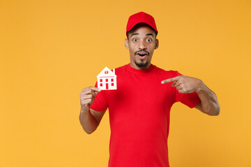 Naklejka premium Delivery employee african man 20s in red cap blank print t-shirt uniform workwear work courier dealer service during quarantine coronavirus covid-19 virus concept isolated on yellow background studio.