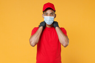 Delivery employee african man in red cap blank print t-shirt face mask gloves uniform work courier dealer service on quarantine coronavirus covid-19 virus concept isolated on yellow background studio.