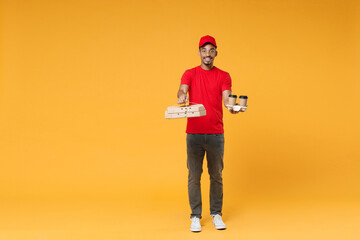 Fototapeta na wymiar Full length delivery employee african man in red cap blank print t-shirt uniform work courier dealer service concept hold give food order pizza cardboard boxes isolated on yellow background studio