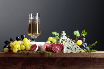 White wine and snacks on an old wooden table.