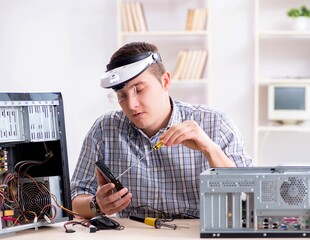 Young technician repairing computer in workshop