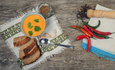 Pumpkin soup with brad onions and red pepper on the wooden table, top view