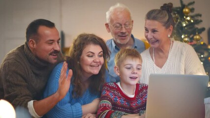 Happy caucasian family having video call using laptop celebrating christmas at home - Powered by Adobe