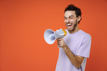 Laughing cheerful funny excited young bearded man 20s wearing casual basic violet t-shirt standing...