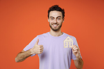 Smiling cheerful young bearded man 20s wearing casual basic violet t-shirt standing hold in hand...