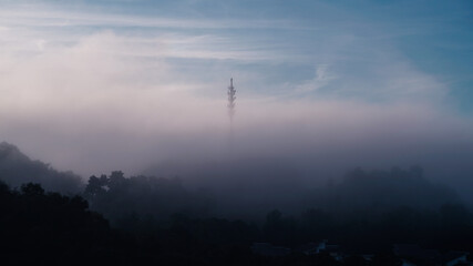 Early morning sunrise with thicker fog or mists over a 5G comm tower