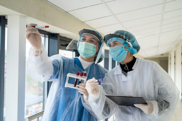 interns record the results of a laboratory test for coronavirus in a modern clinic