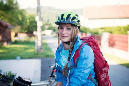 Young woman with helmet riding a bicycle. Enjoying sport in nature. 