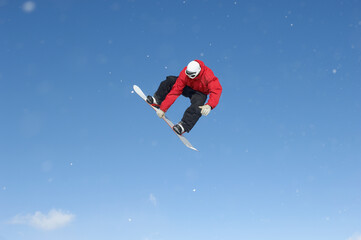 Snowboard Free Rider Making High Jump Against Blue Sky