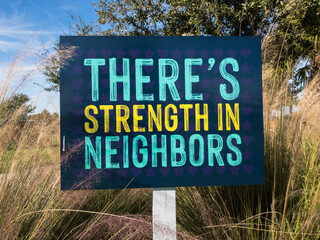 There's Strength in Neighbors Sign in a Suburban Neighborhood