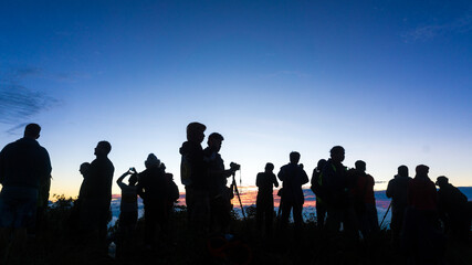 Fototapeta na wymiar Group of silhouette happy travel friends on background of sunset or sunrise high mountain