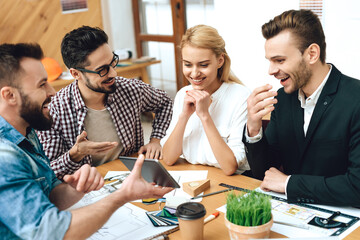 Group of designers architects look at tablet.