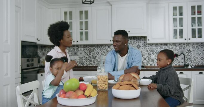 Portrait of good-looking lovling happy african american family which gethering together in contemporary kitchen and have breakfast,close up ,4k