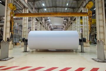 Jumbo reel of paper in Paper mill for a resize. © Thanunsak