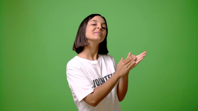 Young volunteer woman on green screen chroma key background applauding after presentation in a conference
