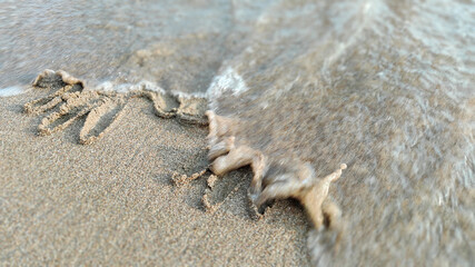 handprint on the sand by the sea