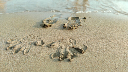 handprint on the sand by the sea