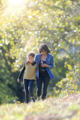 Fototapeta premium Mother and daughter picking flowers in countryside