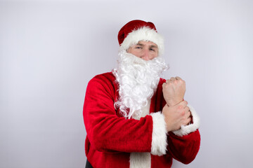 Fototapeta na wymiar Man dressed as Santa Claus standing over isolated white background suffering pain on hands and fingers