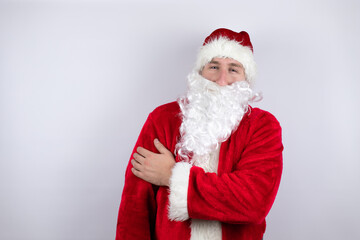 Man dressed as Santa Claus standing over isolated white background with pain on his shoulder and a painful expression