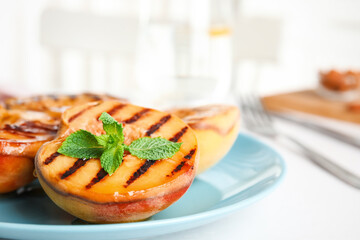 Delicious grilled peaches with honey and mint on white table indoors, closeup. Space for text