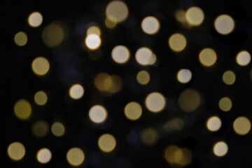 Golden particles bokeh and lens flare on dark background
