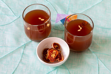 Dessert Korean punch with persimmon, cinnamon, and ginger which is called Sujeonggwa