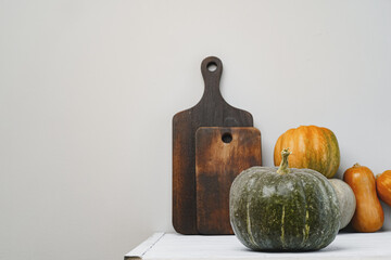 Pumpkins on kitchen table against grey wall
