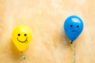 Positive and negative emotions background. Sad and happy faces on ballons