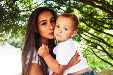 young pretty brunette mother with little cute boy walking in park happy smiling, lifestyle people concept