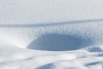 Obraz premium Hole in snow on sunny day