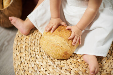 Toddler holding fresh round bread