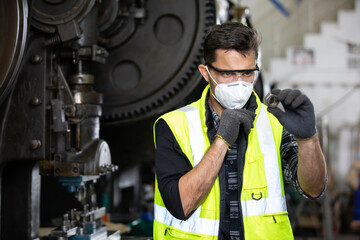 Fototapeta na wymiar engineer man or factory worker wearing protective face mask and looking screw