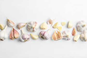 Fresh organic garlic on white wooden table, flat lay