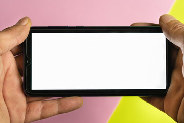 Mockup of hands holding and using a smart phone with white blank screen.Screen background, lifestyle concept.Copy space.
