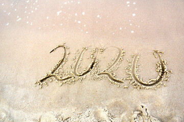 2020 text painted on the sand. Water washed away the text on the beach. The 2021 year is coming