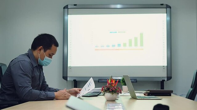 Businessmen wearing protective masks discussing and work together in meeting room. Social distance practice prevent coronavirus COVID-19.
