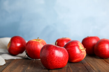 Ripe red apples on wooden table. Space for text
