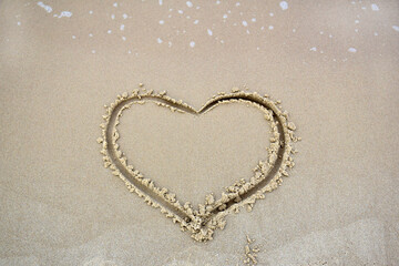 Finger drawn heart on wet sand at the beach. Romantic trip to the sea. Sign of love