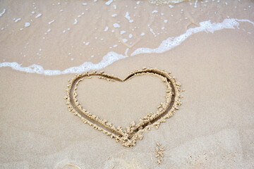Finger drawn heart on wet sand at the beach. Romantic trip to the sea. Sign of love