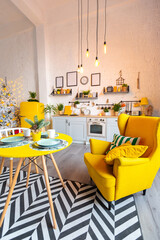 Trendy fashion luxury interior design in Scandinavian style of studio apartment with bright yellow furniture and decorated with new year lights.