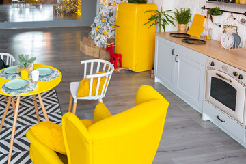 Trendy fashion luxury interior design in Scandinavian style of studio apartment with bright yellow furniture and decorated with new year lights.