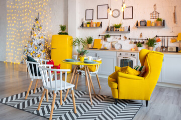 Trendy fashion luxury interior design in Scandinavian style of studio apartment with bright yellow furniture and decorated with new year lights.