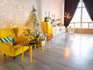 Trendy fashion luxury interior design in Scandinavian style of studio apartment with bright yellow furniture and decorated with new year lights.