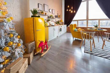 Trendy fashion luxury interior design in Scandinavian style of studio apartment with bright yellow furniture and decorated with new year lights.