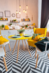 Trendy fashion luxury interior design in Scandinavian style of studio apartment with bright yellow furniture and decorated with new year lights.