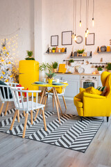 Trendy fashion luxury interior design in Scandinavian style of studio apartment with bright yellow furniture and decorated with new year lights.