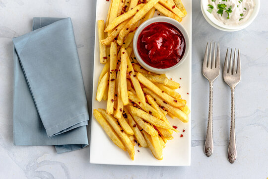 French Fries  on a Platter with Tomato Ketchup and Mayonnaise Directly Above Horizontal Photo on White Background