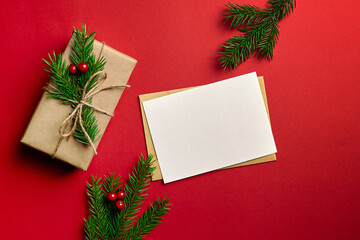 Fototapeta na wymiar Christmas greeting card mockup with decorated gift box on red background